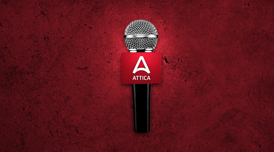 Silver microphone with red Attica branded windscreen on red background